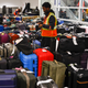 An Oakland International Airport employee tries to organize hundreds of suitcases separated from their owners because of flight cancelations by Southwest